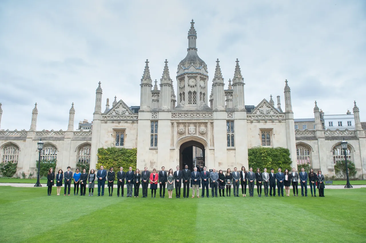 A large department group photograph on the lawn in front of a Cambridge college