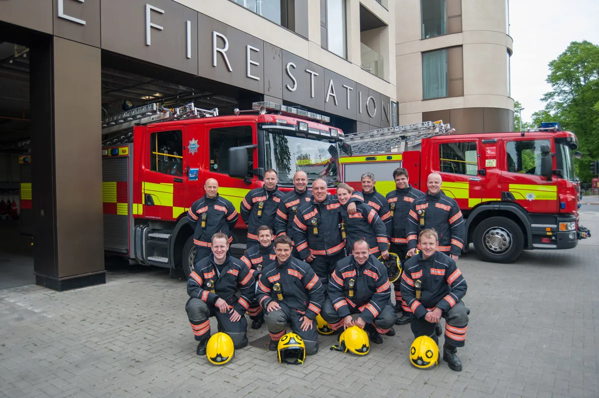 A fire crew group photograph in front of fire engines outside a Cambridge fire station