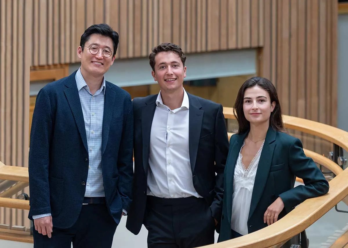The three CardiaTec founders standing together beside a curved timber balustrade