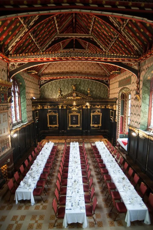 Long tables set for a dinner in Queens’ College dining hall