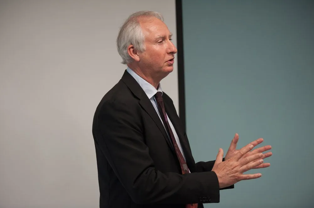 Cambridge MP Daniel Zeichner speaking and gesturing against a plain wall