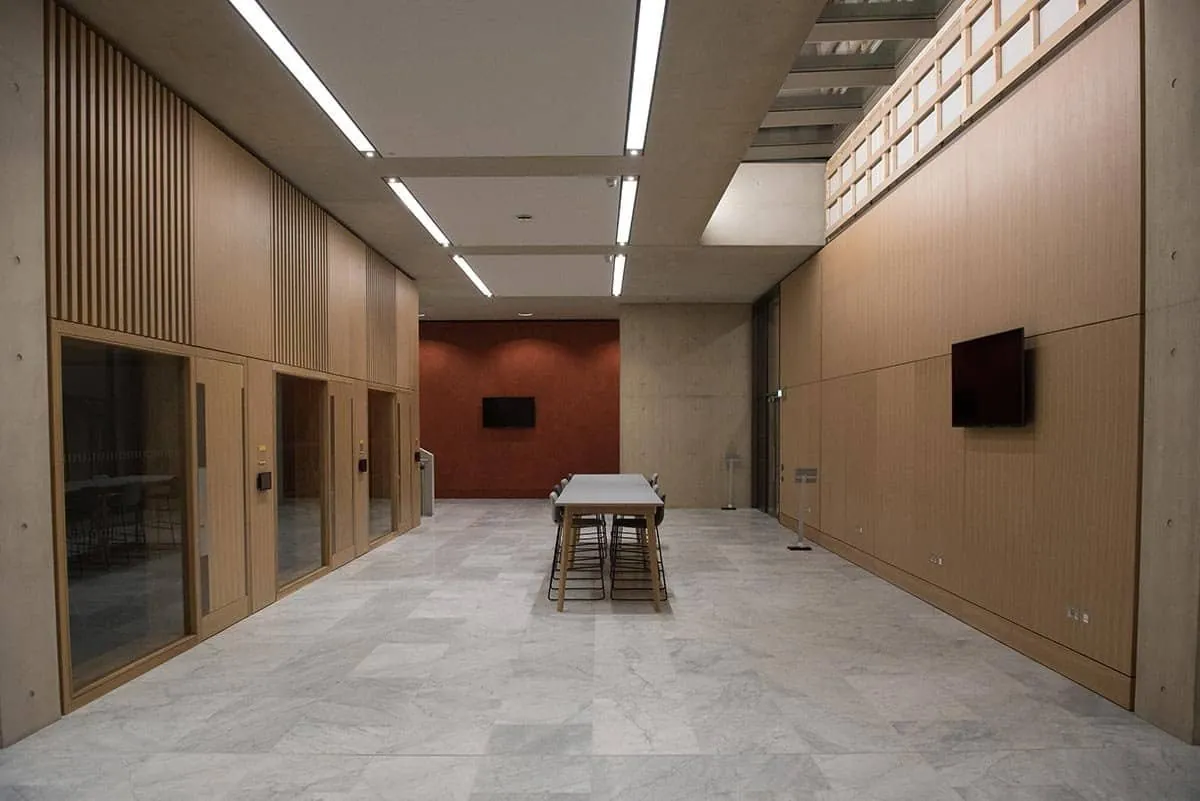 A long timber-panelled corridor with a single table, in a Cambridge business school