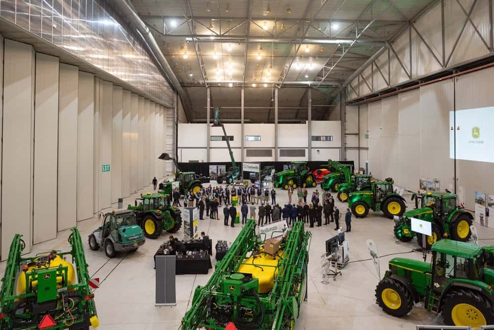 High-quality corporate photography at agricultural machinery exhibition in industrial warehouse.