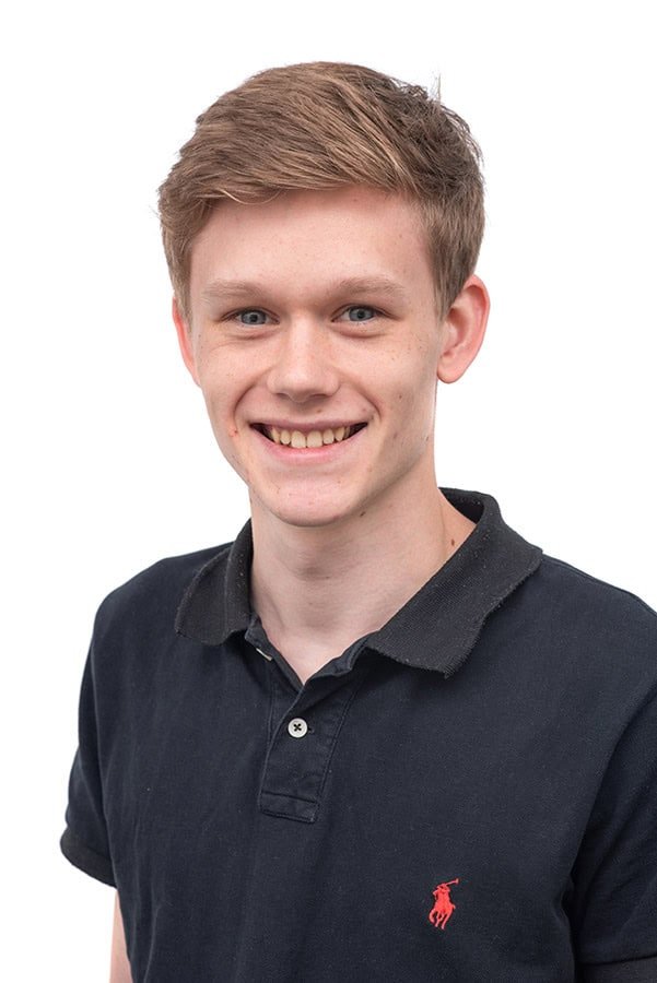 Bright young man smiling in professional headshot for corporate photography.
