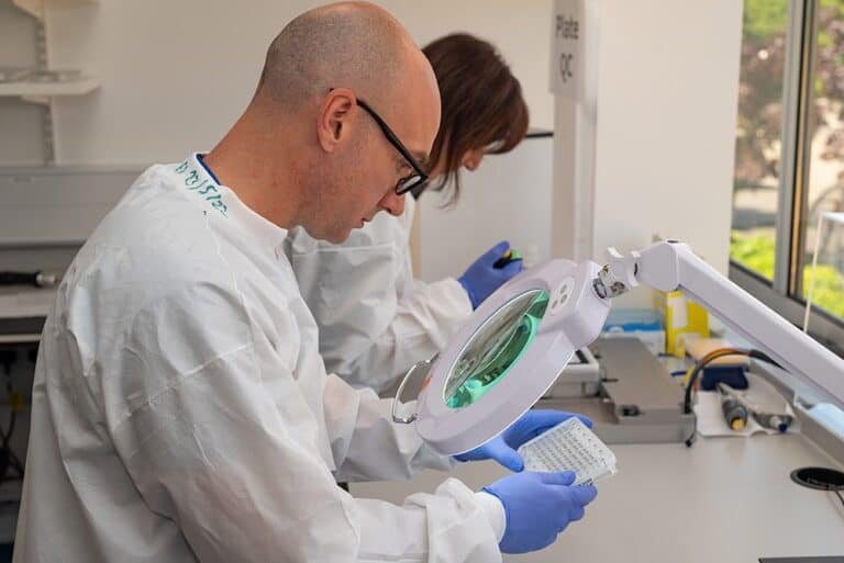 1. Medical laboratory professionals conducting testing with magnifying tools.
